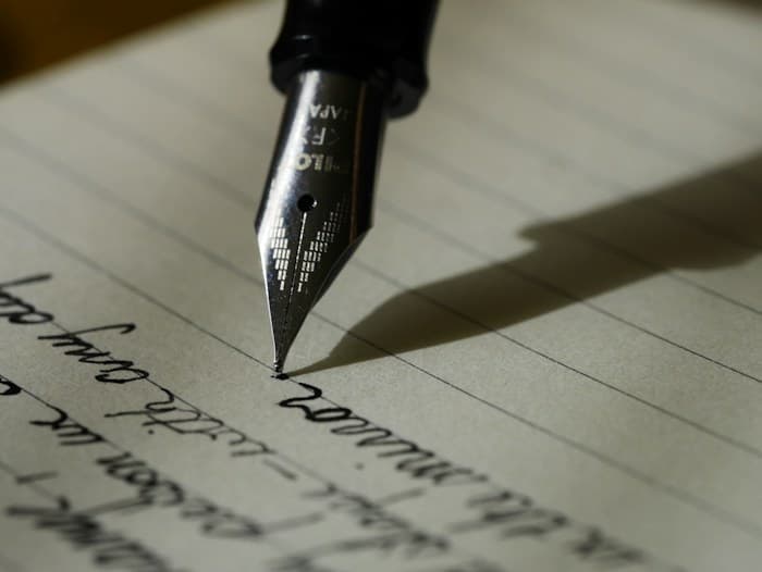 A fountain pen writing in a notebook